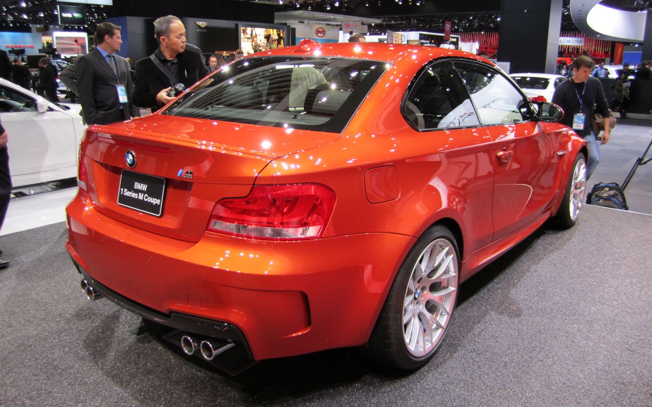 Rear three-quarter view of an orange BMW 1 Series M Coupe on the stand at the 2011 Detroit motor show