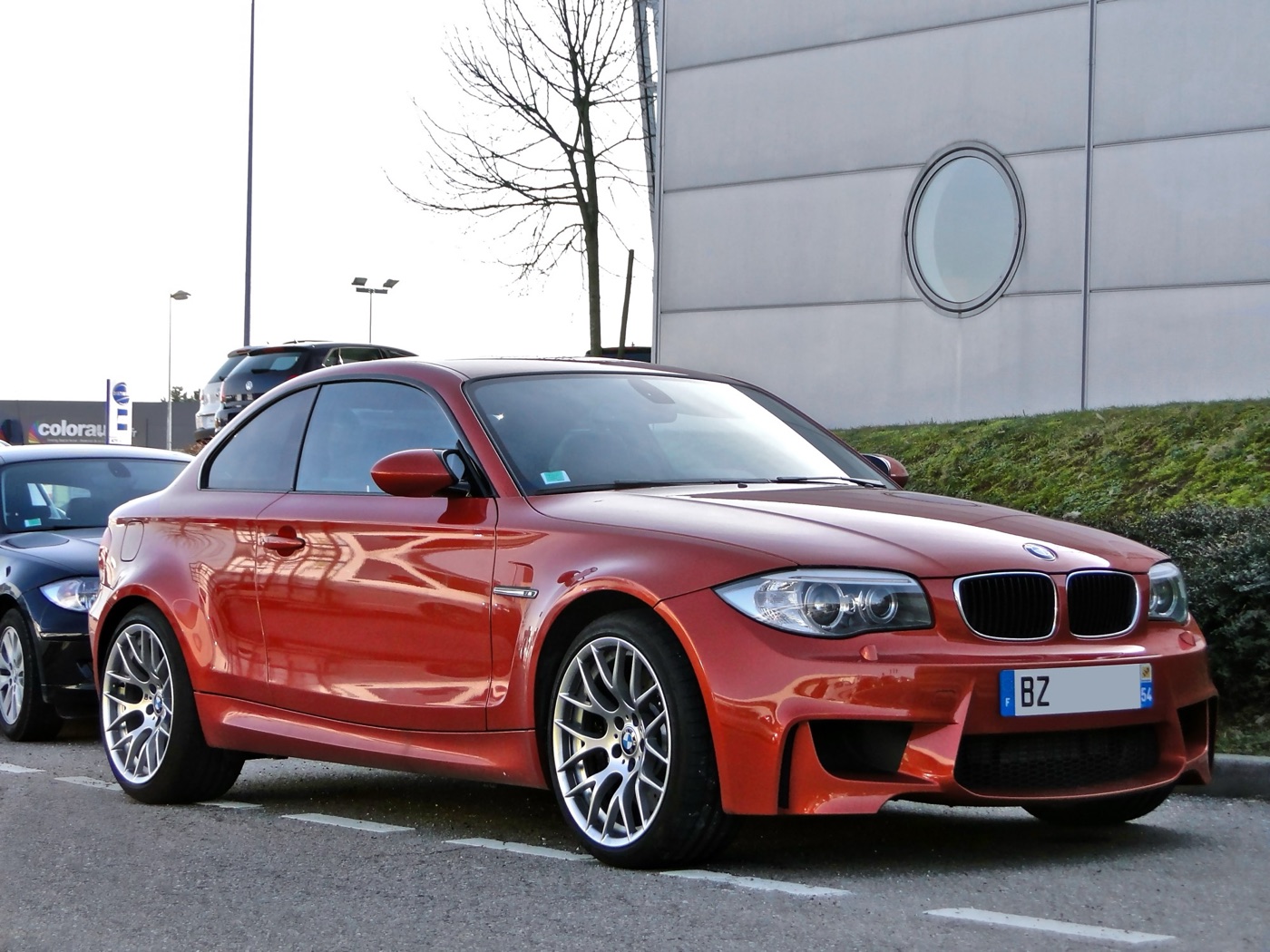 Valencia Orange BMW 1M with French number plate parked outside a modern building